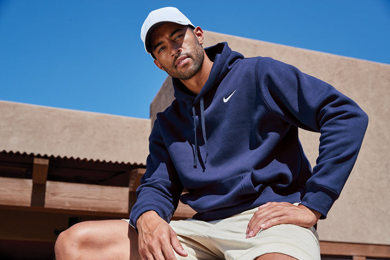 Lifestyle shot of male model in navy K-state Nike hooded sweatshirt