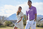 Lifestyle photo of one female and one male golfing..  Both wearing  nike polos