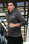 Lifeystyle shot of male model running wearing Nike grey hooded sweatshirt embroidered with K-STATE on left chest