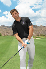 Lifeystyle model shot. Male golfing wearing the Nike Polo embroidered with the K-state Powercat logo.  Black polo with white pants.